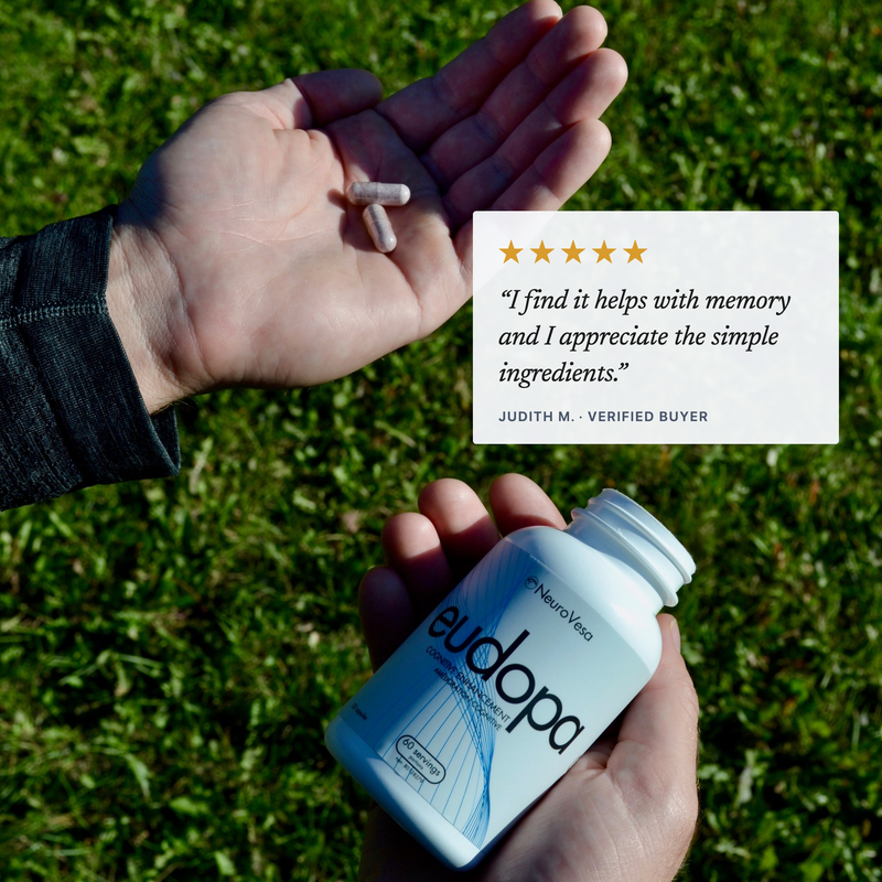 Five-star eudopa review over a photo of two capsules in an open palm and the bottle in hand: 'I find it helps with memory and I appreciate the simple ingredients.' - Judith M., verified buyer.